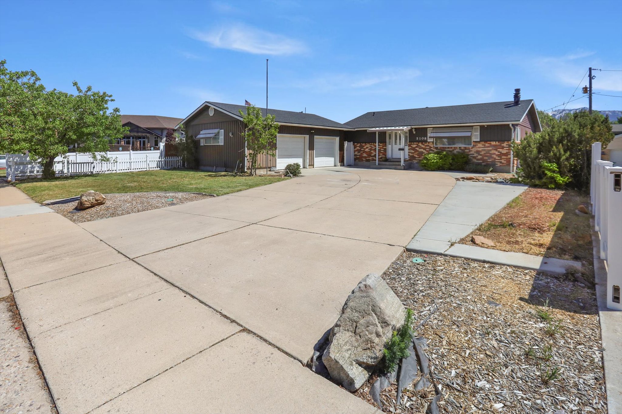 Single story home featuring an attached garage, concrete driveway, and brick siding with RV parking