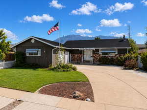 Ranch-style home with driveway, a mountain view, board and batten siding, and brick siding