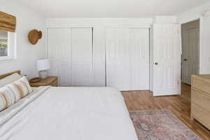 Bedroom featuring two closets and light wood finished floors