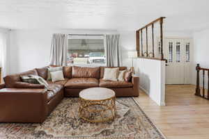 Living room featuring light wood-style flooring and a textured ceiling