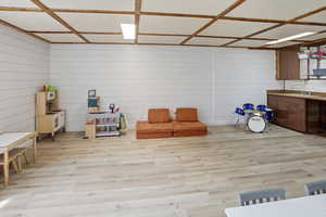 Playroom featuring light wood-style flooring and wooden walls