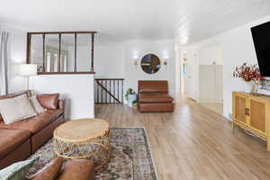Living area featuring light wood-style flooring and a textured ceiling