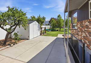 Fenced backyard featuring a storage shed