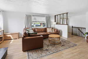 Living room featuring light wood-style floors and a textured ceiling
