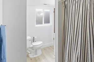 Bathroom featuring a shower with curtain and light wood finished floors