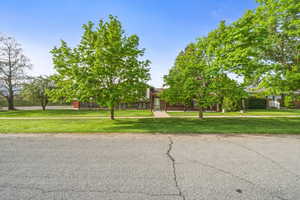 Spacious front yard framed by mature shade trees, offering a peaceful setting and excellent street presence.