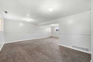 Expansive basement family room with new carpet, offering plenty of space for entertaining, relaxing, or a media area.