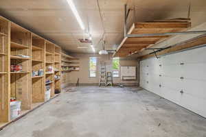 Oversized garage with extensive built-in shelving and workspace, perfect for storage, hobbies, or projects.