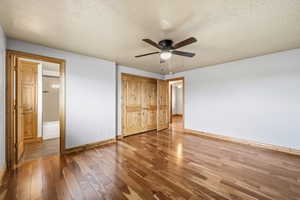 Large bedroom featuring hardwood floors, ample closet space, and direct access to an adjoining bathroom.