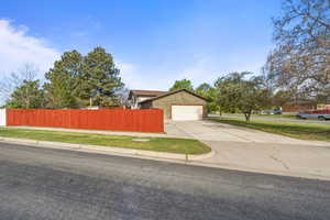 Corner lot with extended driveway and attached garage, providing additional parking and easy access.