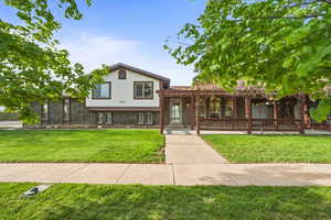 Beautiful multi-level home with classic brick exterior, well-maintained landscaping, and a welcoming covered front entry.