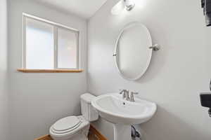 Convenient main-level half bathroom with pedestal sink and natural light.