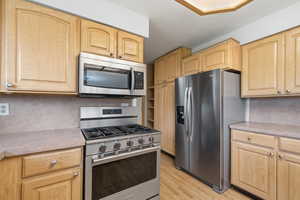 Well-equipped kitchen featuring stainless steel appliances, including a gas range and built-in microwave.