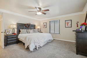 Bedroom featuring crown molding, light colored carpet, and a ceiling fan