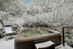 Wooden terrace featuring a hot tub