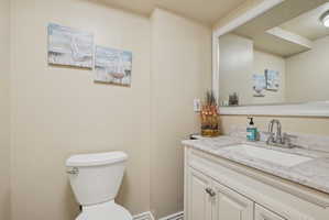 Half bathroom featuring vanity and toilet