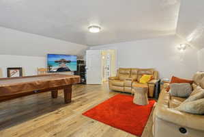Game room featuring a textured ceiling, pool table, and hardwood / wood-style flooring