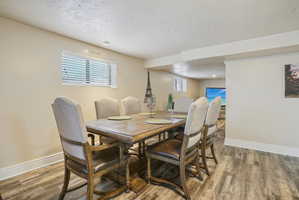 Dining area with a textured ceiling and light wood finished floors