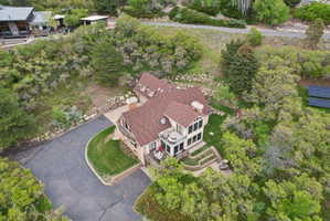 Aerial view of property and surrounding area featuring a tree filled landscape