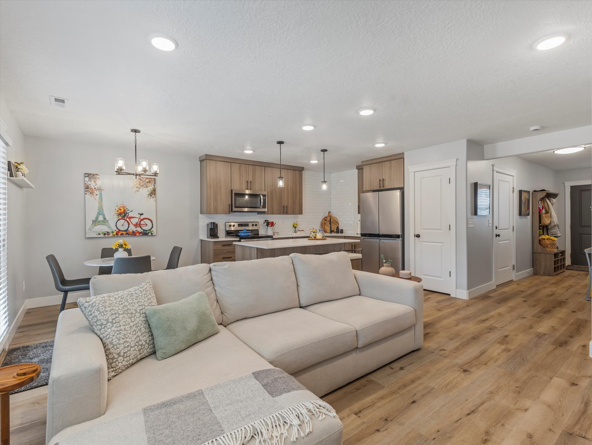Living area featuring light wood-style flooring and hanging lights