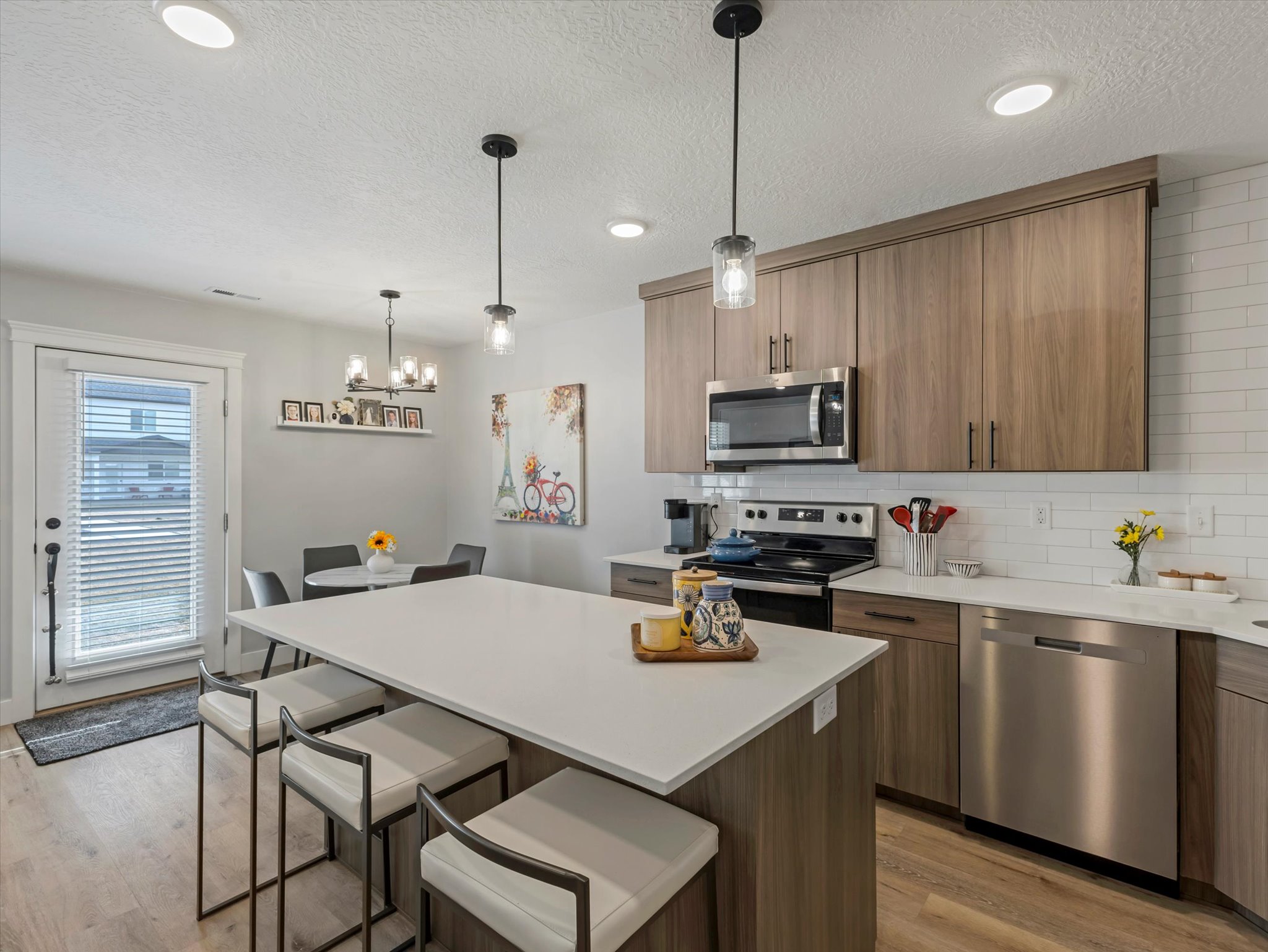 Kitchen with stainless steel appliances, tasteful backsplash, a kitchen breakfast bar, a center island, and light wood finished floors