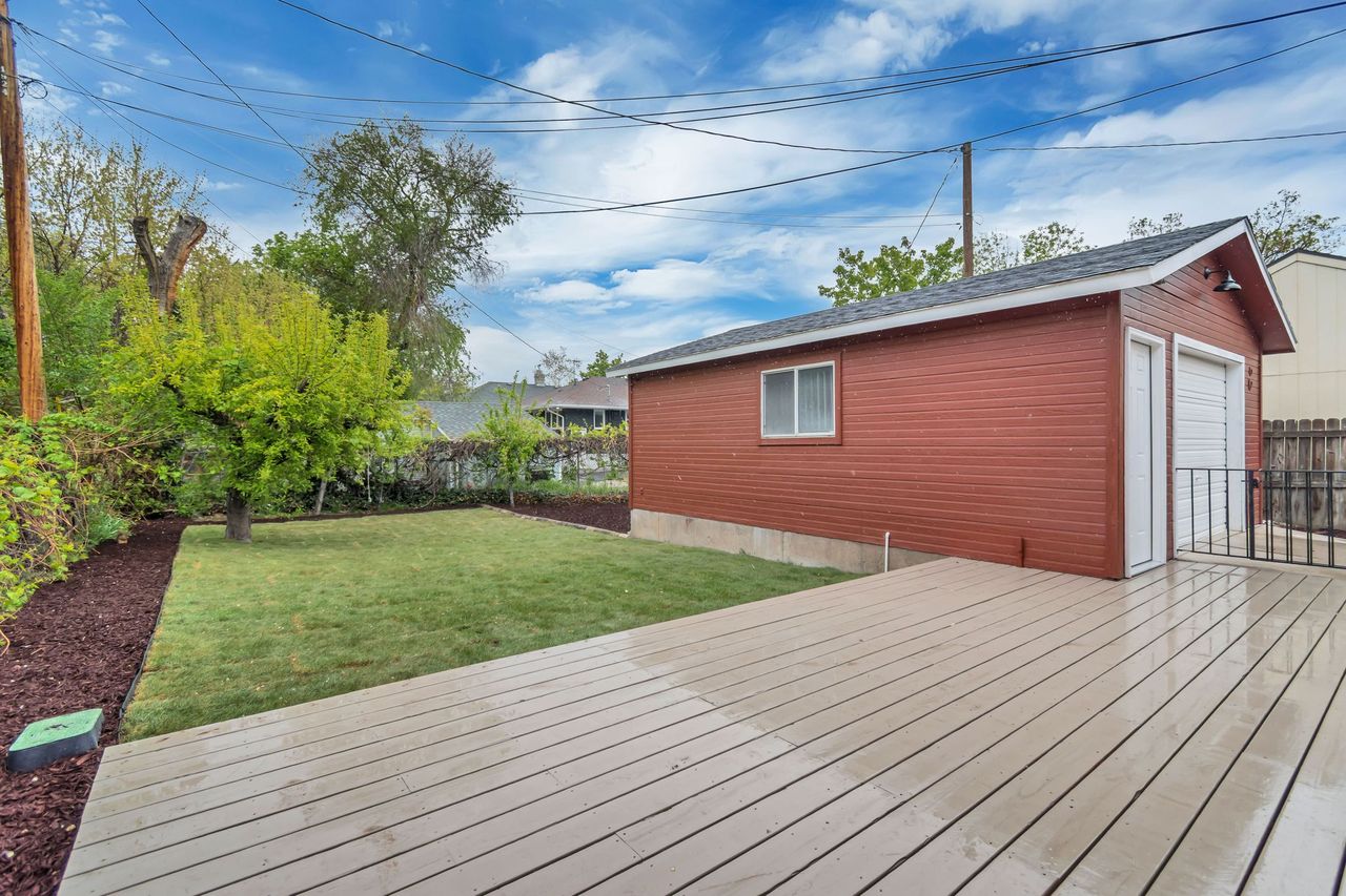 Deck featuring a fenced backyard, an outdoor structure, and a detached garage