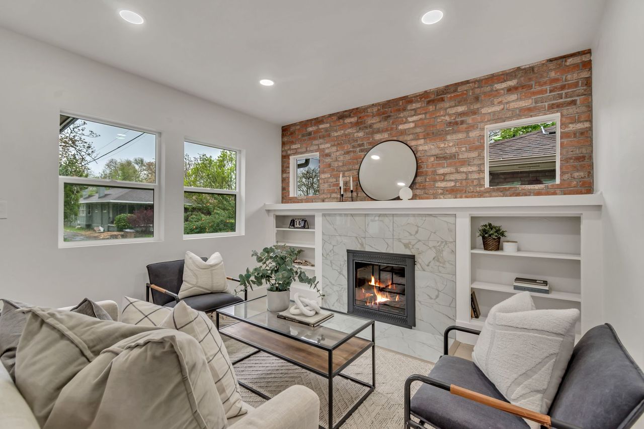 Living area featuring a high end fireplace, built in shelves, and recessed lighting