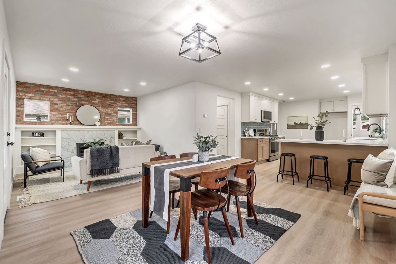 Dining space with a fireplace, light wood-style floors, recessed lighting, and brick wall