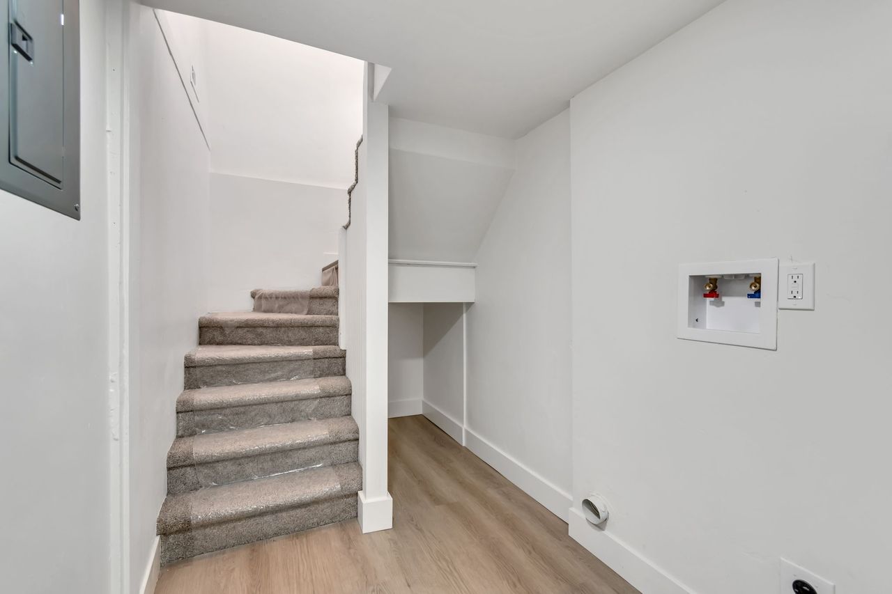 Staircase with electric panel and wood finished floors