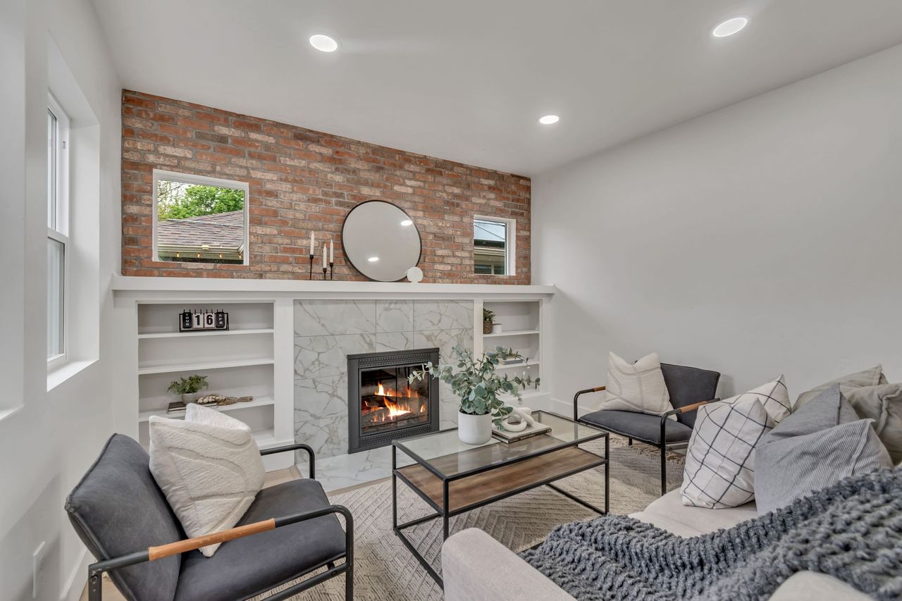 Living room with brick wall, a fireplace, built in features, and recessed lighting