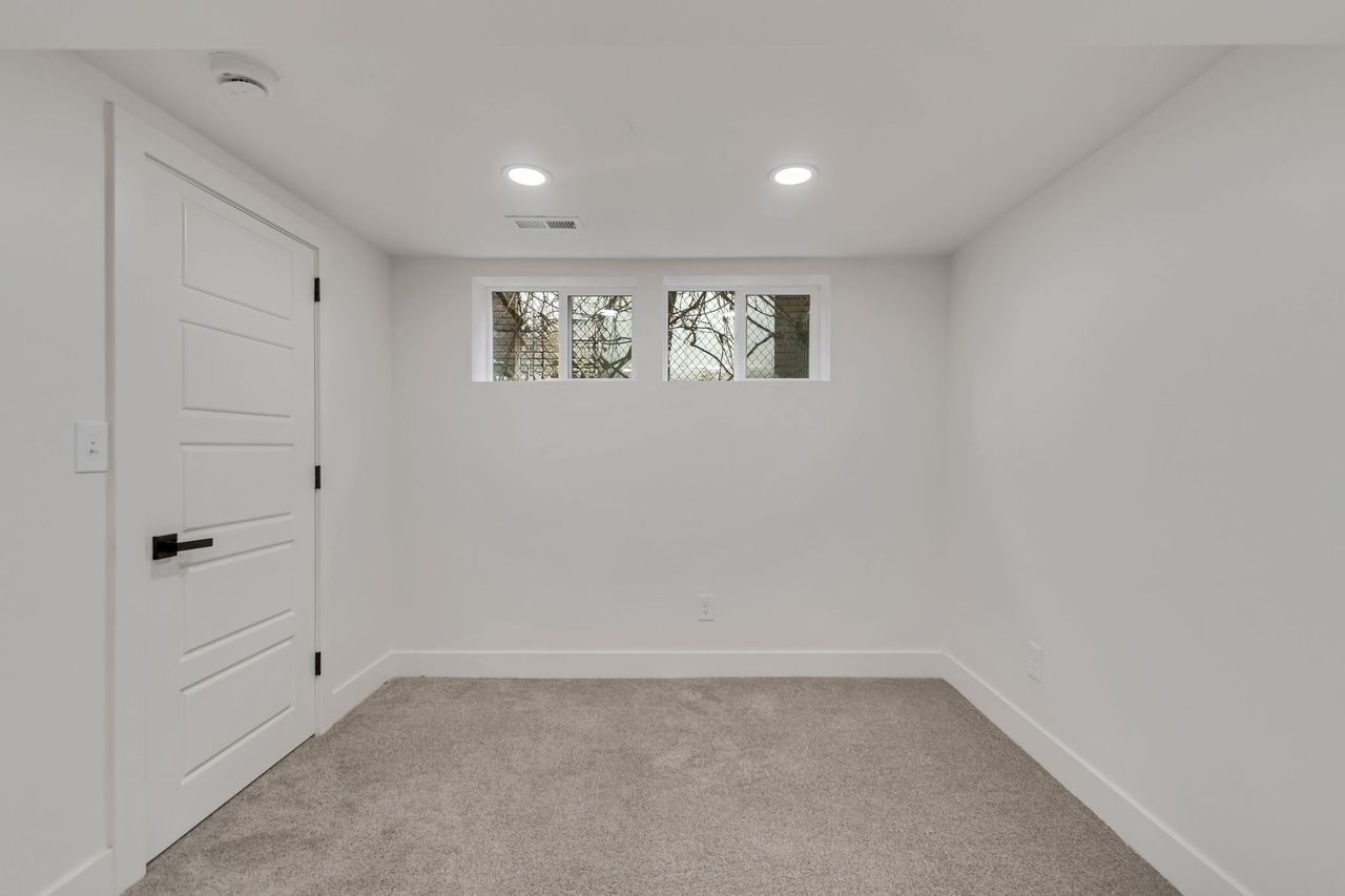 Empty room featuring light colored carpet, recessed lighting, and a smoke detector