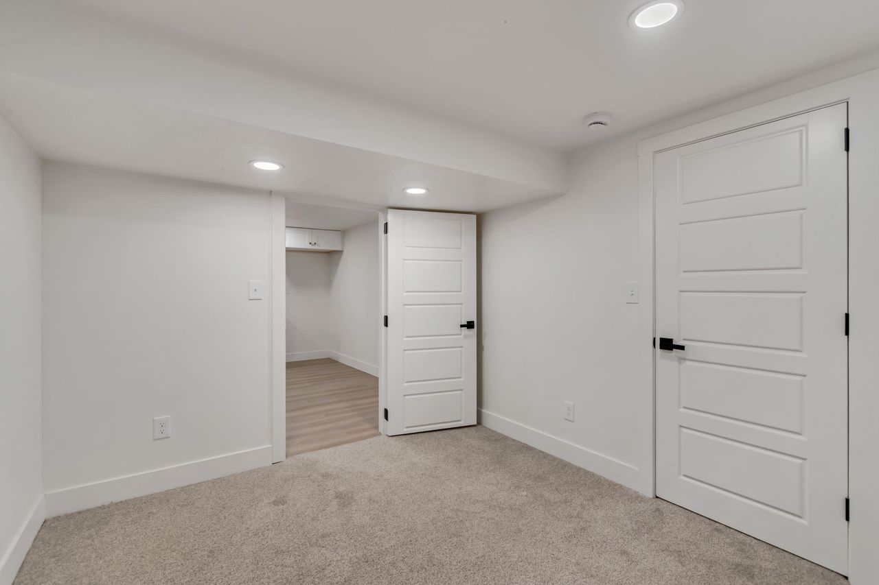 Finished below grade area with recessed lighting and light carpet