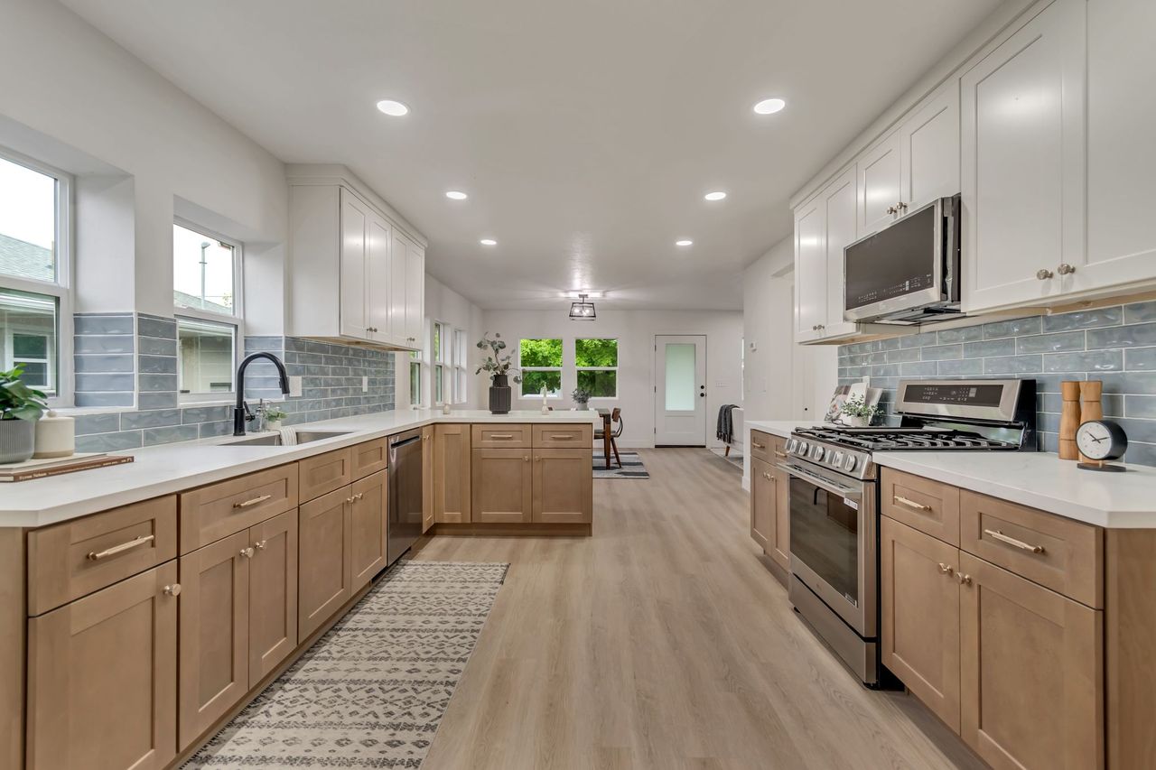 Kitchen featuring stainless steel appliances, decorative backsplash, a peninsula, recessed lighting, and light wood finished floors