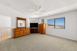 Carpeted bedroom with a ceiling fan and baseboards
