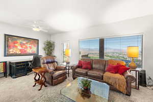 Living area with light colored carpet and a ceiling fan