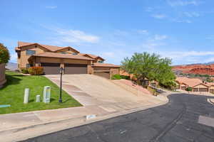 View of front facade featuring an attached garage, driveway, a mountain view, a tile roof, and a residential view