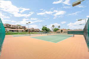 View of tennis court with a residential view