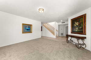 Spare room featuring a textured ceiling and light colored carpet