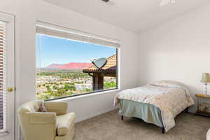 Carpeted bedroom with a mountain view and ceiling fan