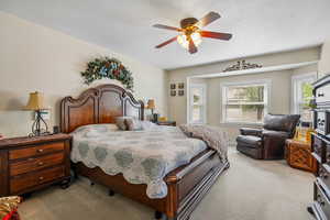 Bedroom featuring carpet floors, a ceiling fan, and a textured ceiling
