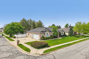 Single story home with concrete driveway, brick siding, a garage, and a shingled roof