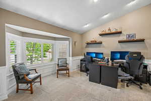 Office space featuring a decorative wall, wainscoting, and light colored carpet