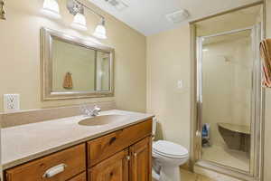 Full bathroom featuring a shower stall, vanity, and light tile patterned flooring