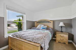 Bedroom featuring baseboards and dark colored carpet