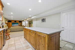 Kitchen featuring light countertops, recessed lighting, wood finish cabinetry, a center island, and open floor plan