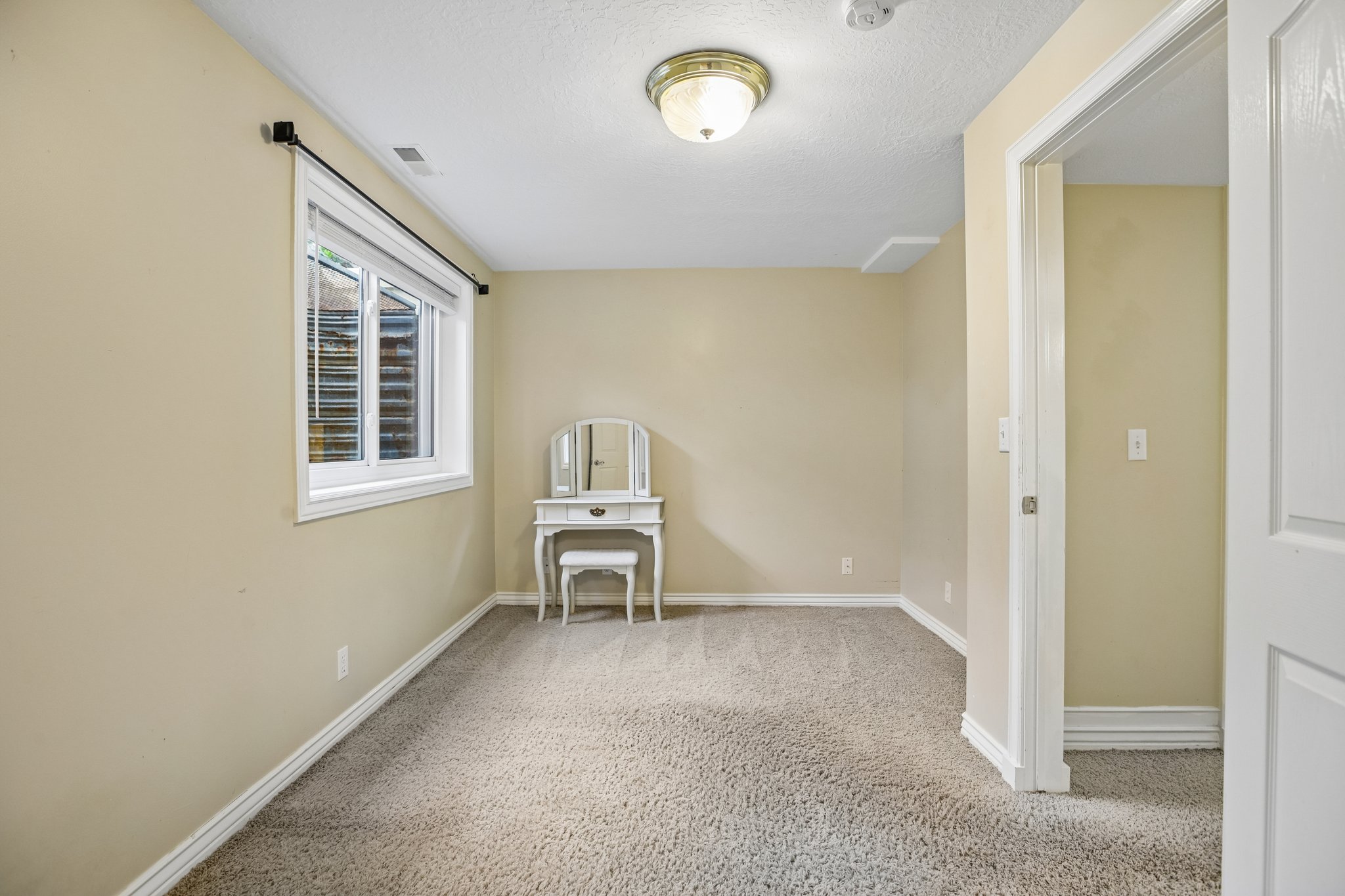 Spare room featuring light carpet and a textured ceiling