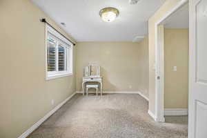 Spare room featuring light carpet and a textured ceiling