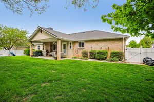 Rear view of property featuring a gate, a fenced backyard, a patio area, a playground, and brick siding