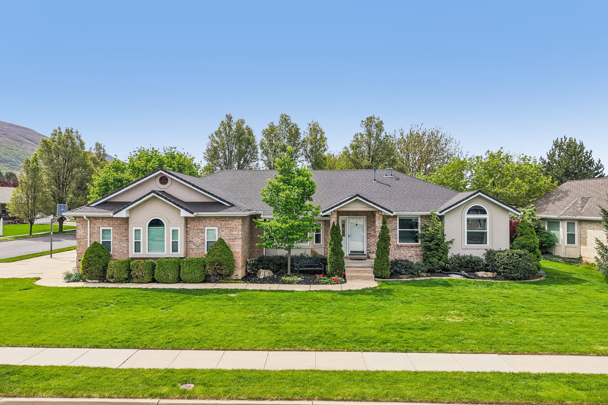 Single story home featuring brick siding, a front yard, and a shingled roof