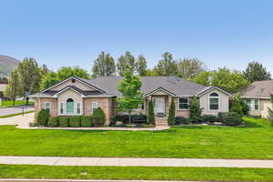 Single story home featuring brick siding, a front yard, and a shingled roof